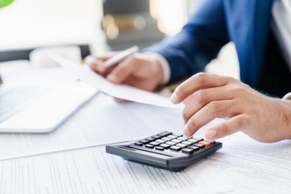 Businessman counting bills savings investments dividends on calculator