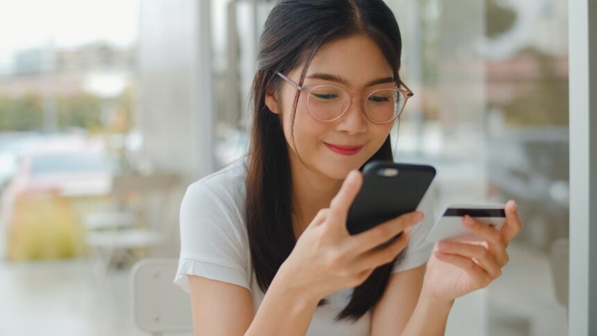 Freelance Asian women online shopping at coffee shop.
