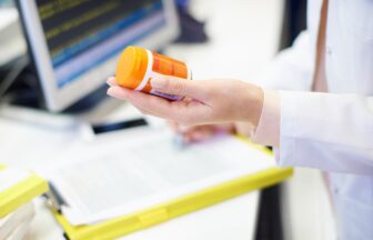 Pharmacist holding pill bottle