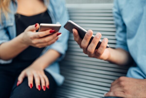 Pareja de adictos al teléfono mirando los smartphones