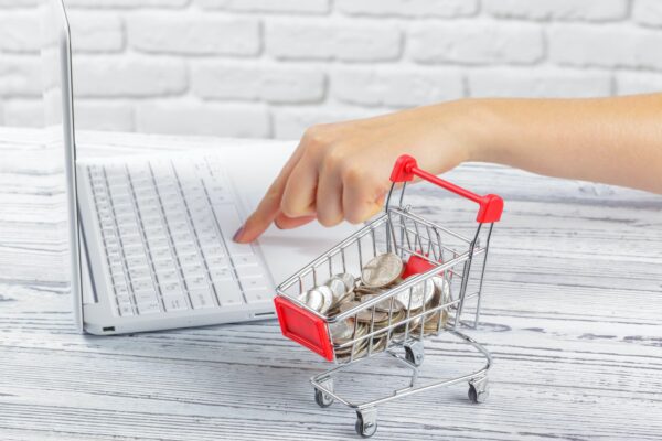 Online-Einkaufskonzept: Mini-Einkaufswagen und Laptop
