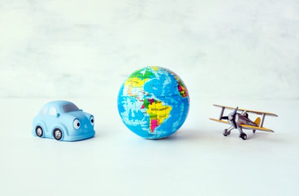 Reisen, Abenteuer, Urlaub Konzept. Gelbes Spielzeug-Flugzeug, blaues Auto und Erdkugel, Karte auf
