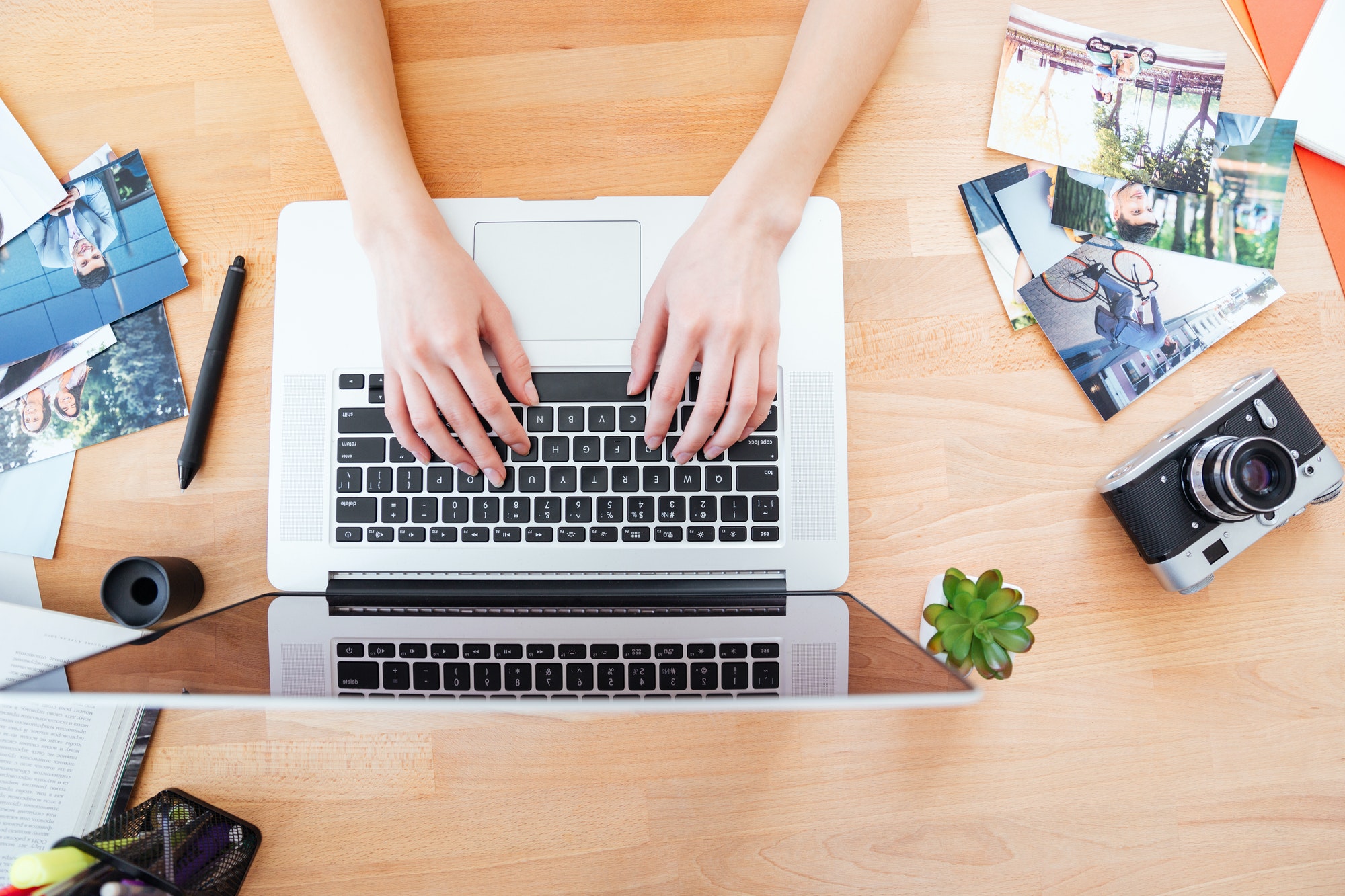 Schreibtisch einer jungen Fotografin bei der Arbeit mit einem Laptop