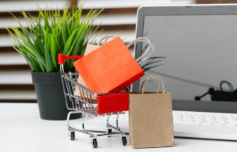 Online shopping concept. Shopping cart, laptop on the desk