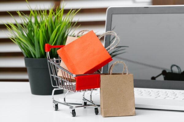 Online shopping concept. Shopping cart, laptop on the desk